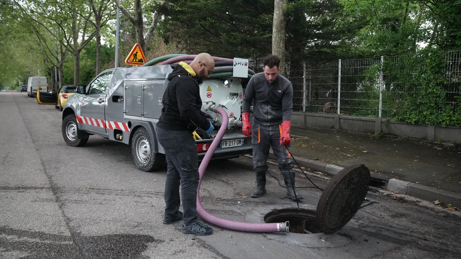 Raccordement du tuyau d'aspiration au camion hydrocureur au-dessus d'un regard ouvert